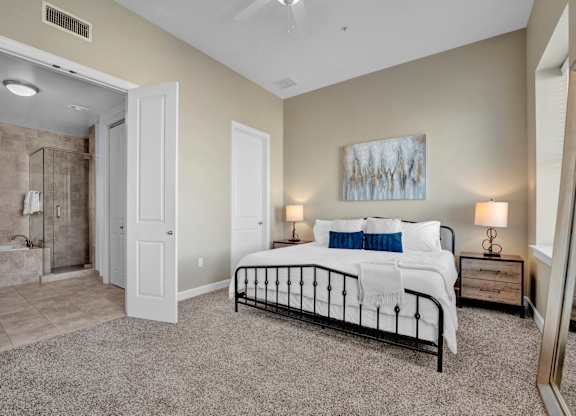 A bedroom with a large bed and a painting on the wall.