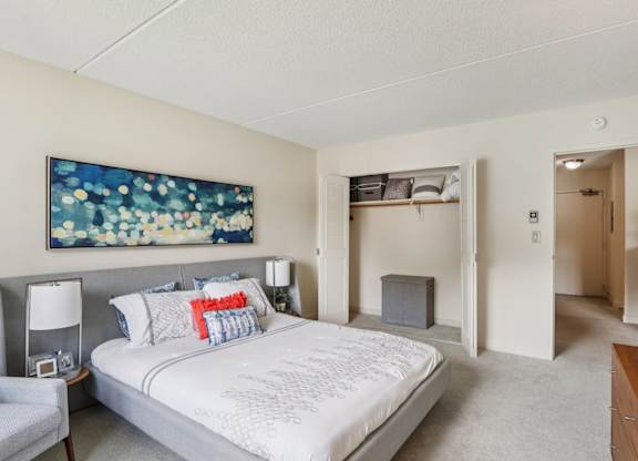 A bedroom with a large bed and a painting on the wall.