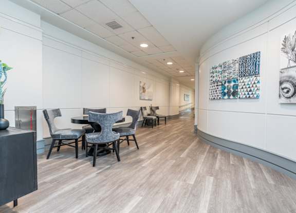 a room with a table and chairs on the left and a hallway on the right