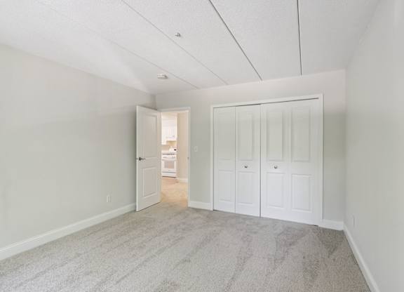 A room with a carpeted floor and white walls.
