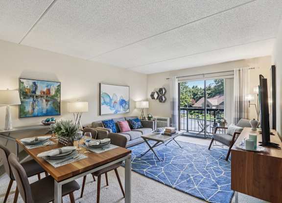 A well-lit living room with a dining table set for two.