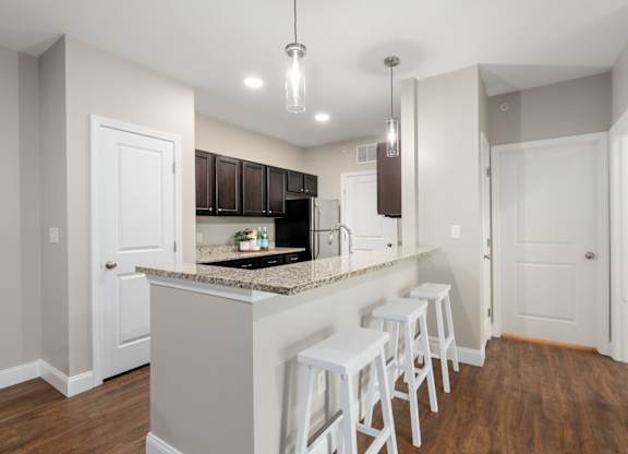 A kitchen with white cabinets and a granite countertop.