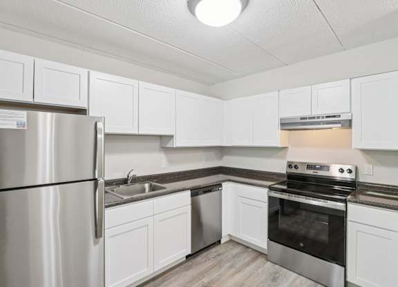 A kitchen with white cabinets and stainless steel appliances.