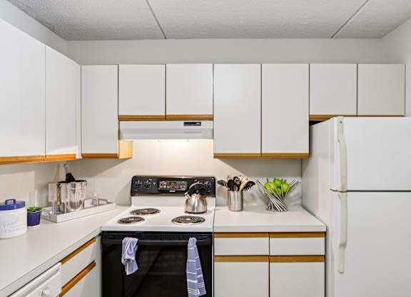 A kitchen with a black stove top oven and white cabinets.