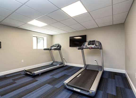 Quincy Commons gym with treadmills and a tv