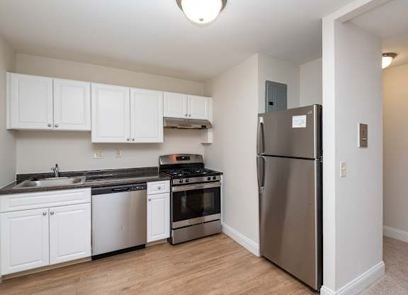 Quincy commons kitchen with white finishes, high quality flooring, and stainless steel appliances