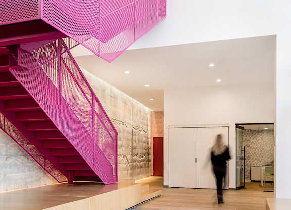 The lobby pink staircase at 3200 Washington with a person blurry.