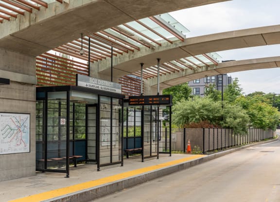 Box District Bus station with walking path, a bus stop on the side of a road