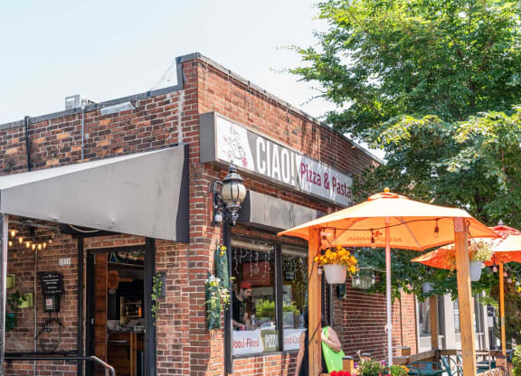 CIAO Pizza, the front of a brick building with umbrellas