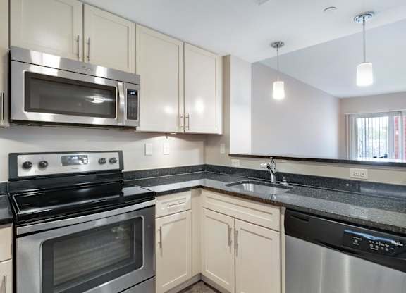 A kitchen with a stainless steel oven and microwave.