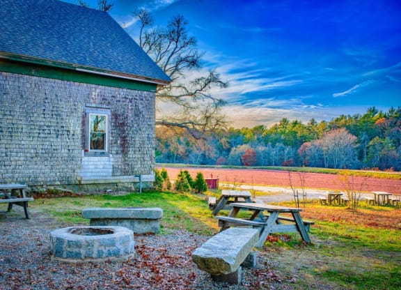 a group of picnic tables in front of a brick building