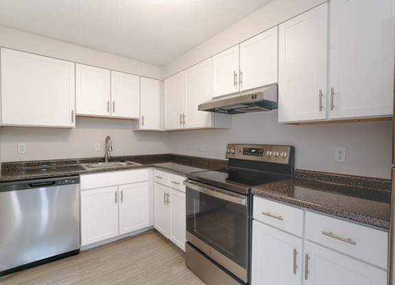 a kitchen with white cabinets and stainless steel appliances