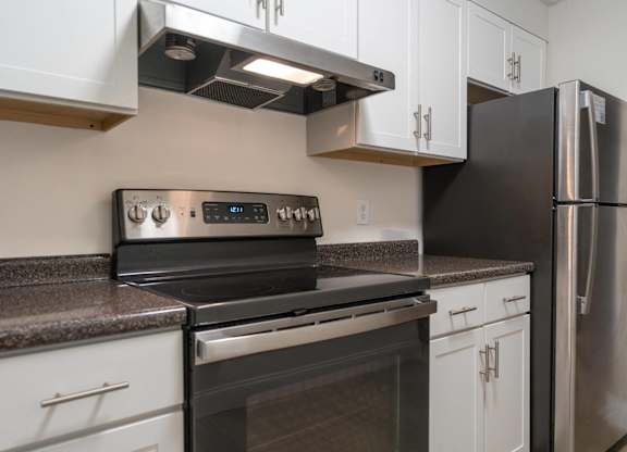 a kitchen with stainless steel appliances and white cabinets