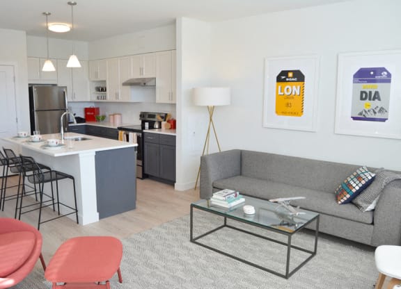 Model apartment kitchen with overhead lights, white counters and breakfast bar