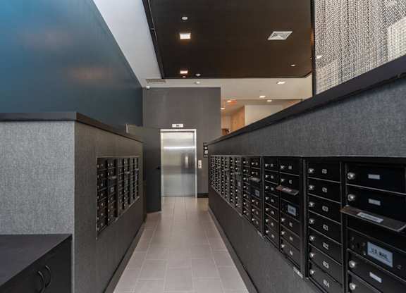 A hallway with a row of mailboxes on the wall.