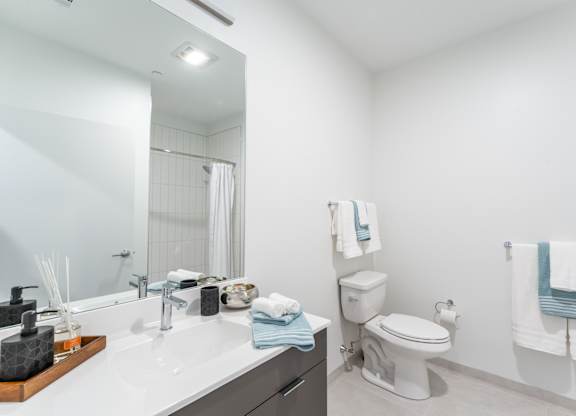 Studio apartment bathroom with large vanity and bright finishes