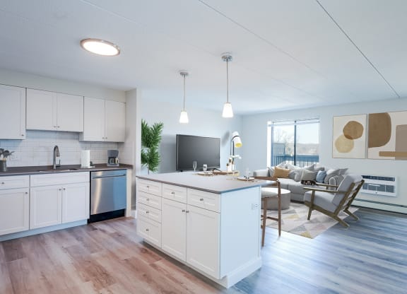 a kitchen and living room with hardwood floors and white cabinets