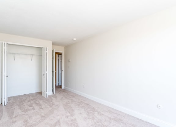 a bedroom with a closet and a closet door open