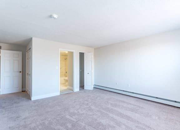 a bedroom with white walls and carpet