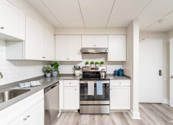 a kitchen with white cabinets and stainless steel appliances