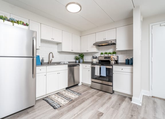 a kitchen with white cabinets and stainless steel appliances
