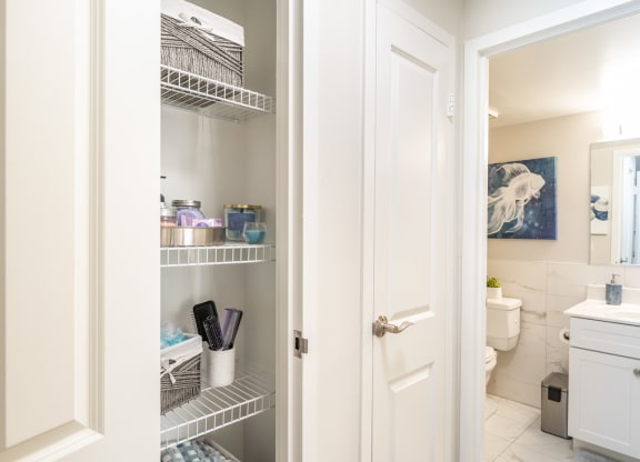 a small bathroom with white cabinets and a white door