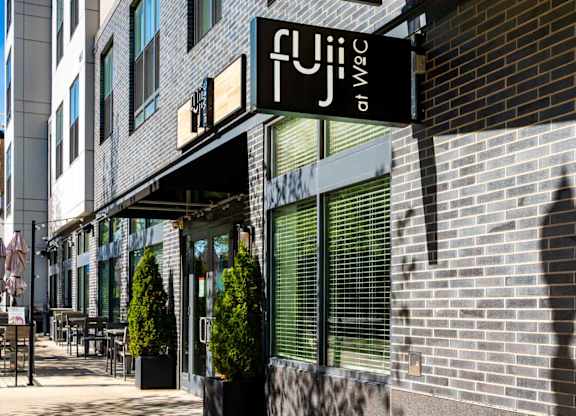 A black and white sign that says Fuji on WoC on a building in Quincy, MA.