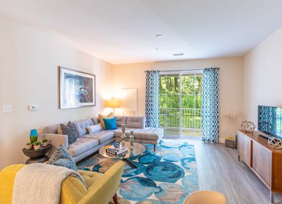 a living room with a couch and a tv and a sliding glass door