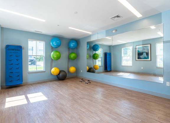 a yoga room with a large mirror and a colorful ball system on the wall