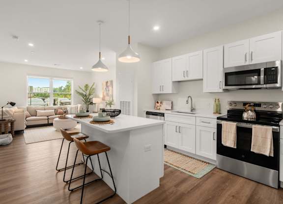 A modern kitchen with a large island and stainless steel appliances.
