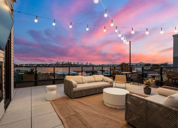 A patio with a couch, chairs, and string lights.