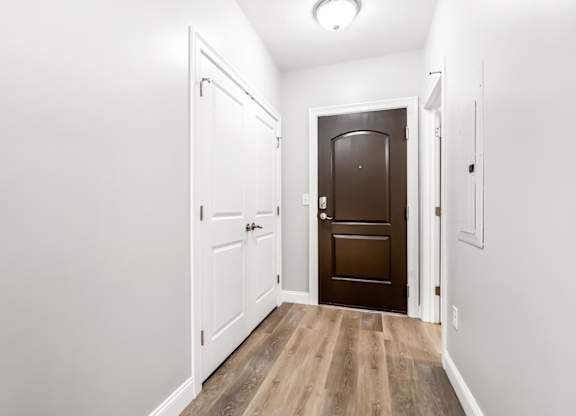 Ashland woods apartment with accented doorway, bright finishes, and vinyl wood flooring.