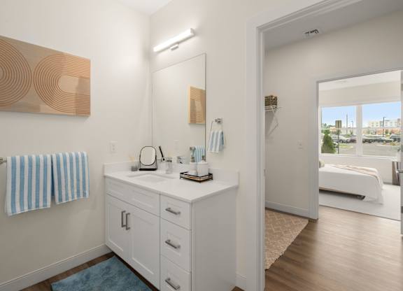 A bathroom with a white vanity and a mirror.