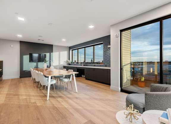 A modern dining room with a long table and chairs.