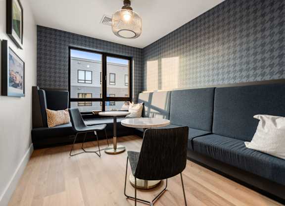 A living room with a black chair and a black sofa.