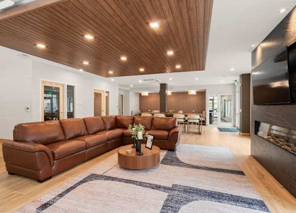 A modern living room with a brown leather sofa and a wooden coffee table.