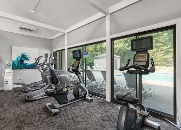 A room with a treadmill, exercise bike, and other equipment.