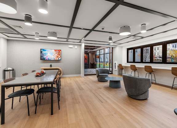 A modern dining room with a long table and chairs.