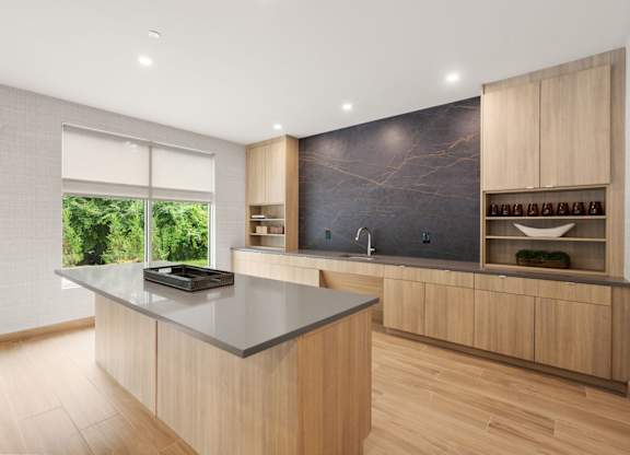 A kitchen with a large island and wooden cabinets.
