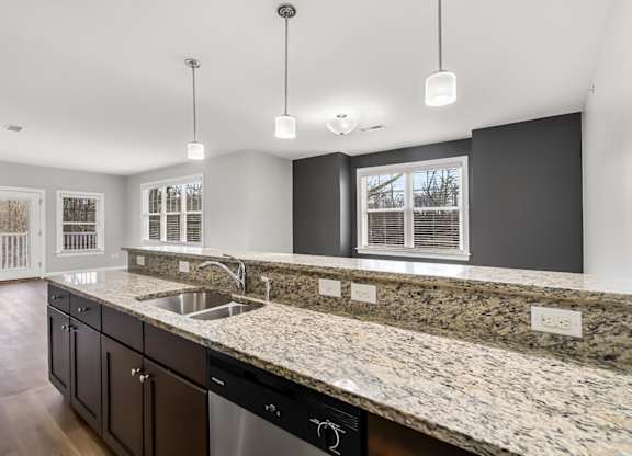 Ashland woods apartment kitchen with stainless steel appliances, stove, microwave, oven, and granite counters. Accent wall in background