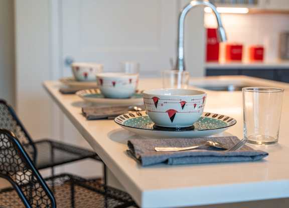 Mastlight apartment kitchen counter with a bowl, a glass, and a plate on it.