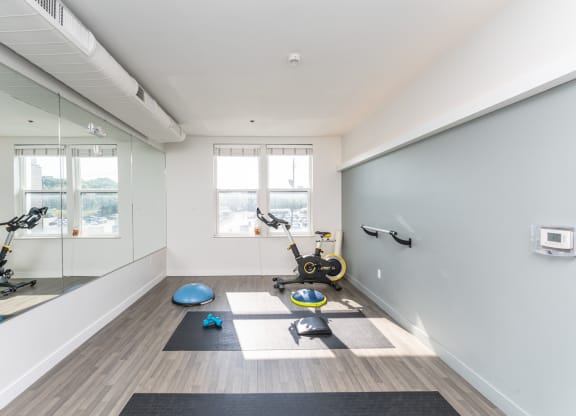 a workout room with yoga equipment and mirrors in a home gym