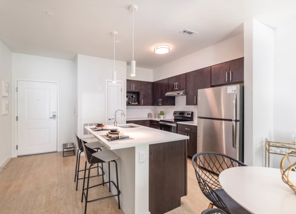 a kitchen with a large center island with a breakfast bar