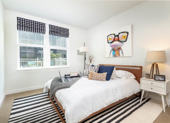 a bedroom with a bed and two windows