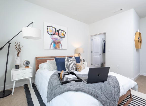 a bedroom with a bed with a laptop on it