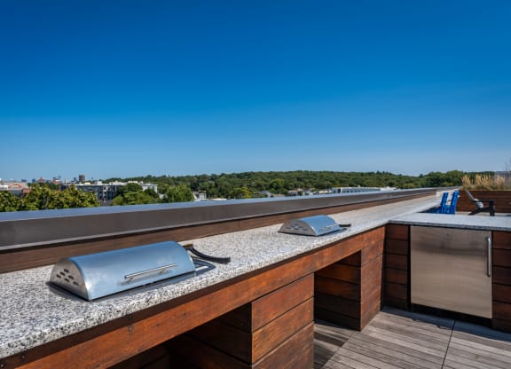 a rooftop terrace with a table with two microwaves on it