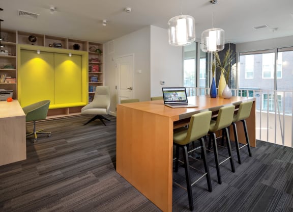 a room with a table and chairs with a laptop on it