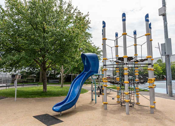 A playground with a blue slide and climbing structure.