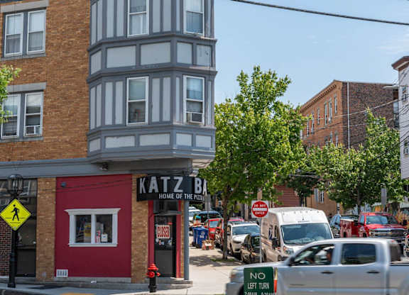 A street view with a red building on the left and a sign that says