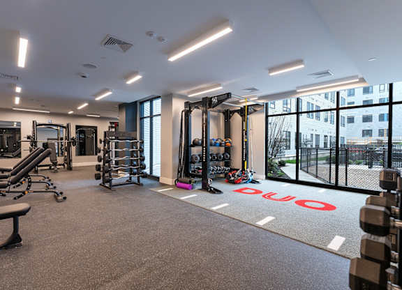 A gym with a variety of equipment including weights and cardio machines.